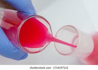 Hand Pouring Red Liquid To The Tube