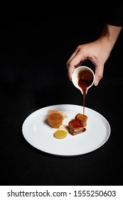 Hand Pouring Sauce Over Food On A Plate, Exquisite Dish, Creative Restaurant Meal Concept
