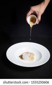 Hand Pouring Sauce Over Food On A Plate, Exquisite Dish, Creative Restaurant Meal Concept
