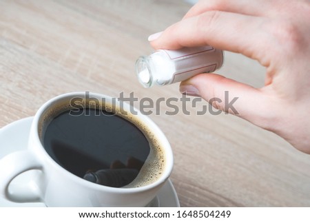 hand pours poison into a Cup of coffee, selective focus, concept of crime poisoning