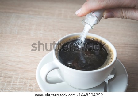 hand pours poison into a Cup of coffee, selective focus, concept of crime poisoning
