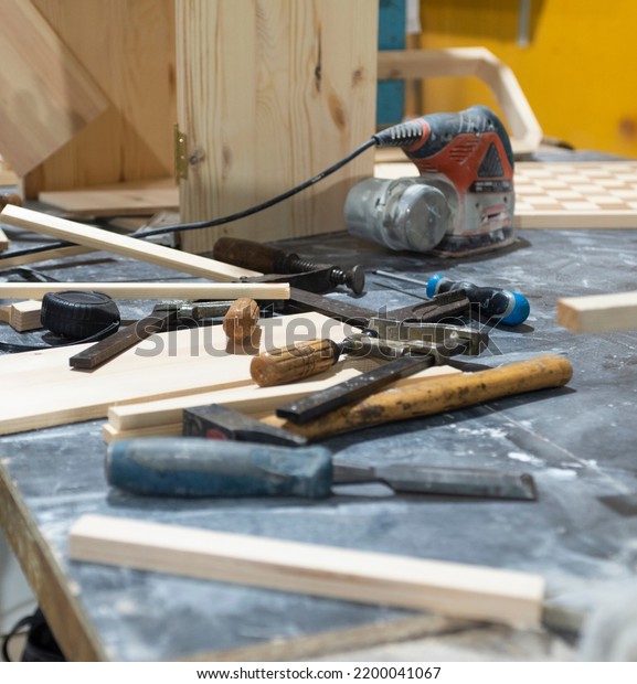 Hand and\
power tools of a carpenter on the\
workbench