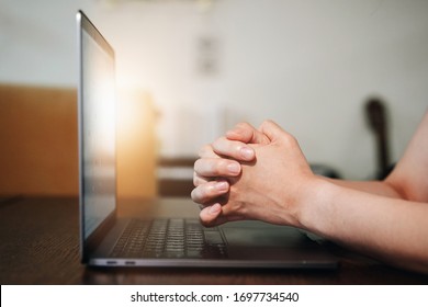 Hand praying with laptop, Church online Sunday services concept, Home church during quarantine coronavirus Covid-19, Hands folded in prayer concept for faith.