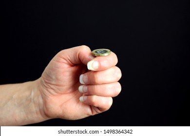 A Hand Preparing To Flip A Pound Coin To Decide Heads Or Tales.