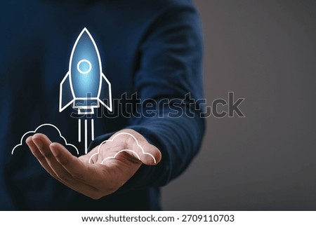 Hand presenting a glowing rocket startup icon, symbolizing business growth, innovation, new beginnings, technology launch, creative ideas, future development, and successful project acceleration.