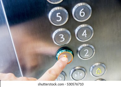 The hand presses on the first floor elevator button - Powered by Shutterstock