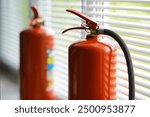 hand presses the trigger fire extinguisher available in fire emergencies conflagration damage background. 