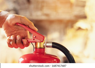 Hand Presses The Trigger Fire Extinguisher Available In Fire Emergencies Conflagration Damage Background. Safety