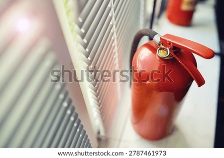 hand presses the trigger fire extinguisher available in fire emergencies conflagration damage background. 