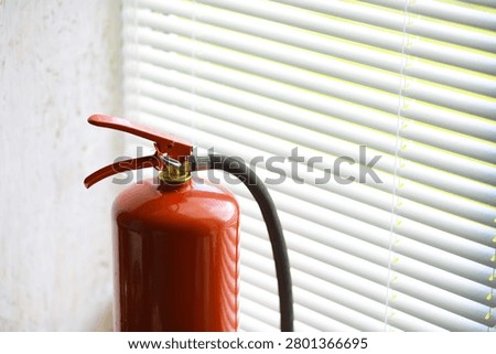 hand presses the trigger fire extinguisher available in fire emergencies conflagration damage background. 
