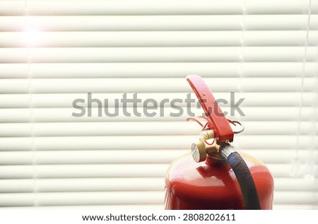 hand presses the trigger fire extinguisher available in fire emergencies conflagration damage background. 