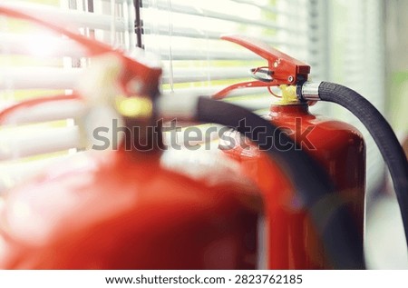hand presses the trigger fire extinguisher available in fire emergencies conflagration damage background. 