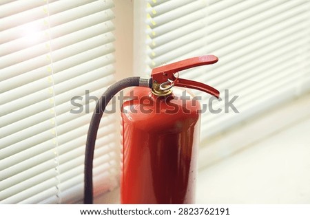 hand presses the trigger fire extinguisher available in fire emergencies conflagration damage background. 