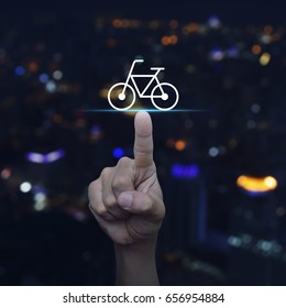 Hand Pressing Bicycle Flat Icon Over Blur Colourful Night Light City Tower, Business Service Bike Concept