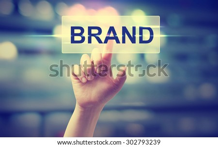 Hand pressing BRAND button on blurred cityscape background