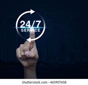 Hand pressing button 24 hours service icon over map and city tower, Full time service concept, Elements of this image furnished by NASA