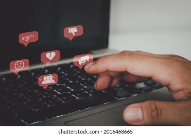 Hand pressing the keyboard of a laptop computer. Icon virtual interface technology concept. Social networks bully Gossips, quarrels, and fake news of a divided society.