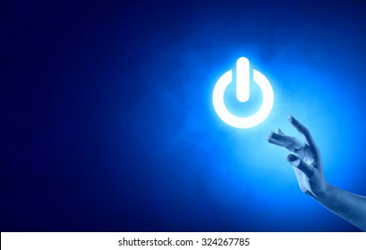 Hand Pressing Power Button On Blue Background