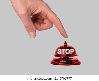Hand pressing reception bell with word stop. Dissent, message to end violence, unemployment, injustice, pollution. Outlook and concept of policy in hotel, store, cafe, restaurant. High quality photo