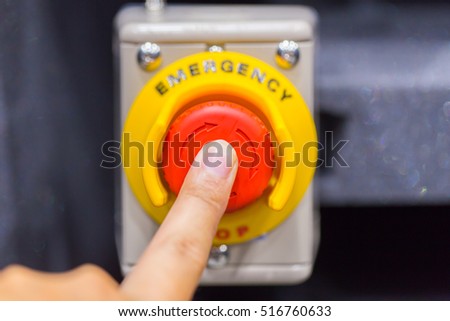 Hand pressing the red emergency button or stop button for industrial machine, Emergency Stop for Safety.
