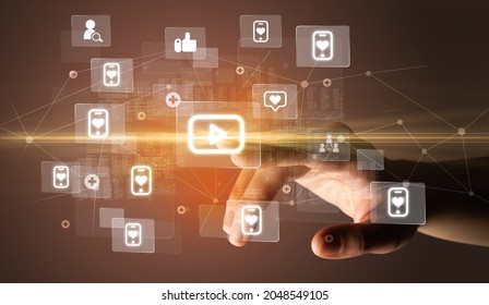 Hand pressing social media multimedia application screen with media icons on futuristic concept - Shutterstock ID 2048549105