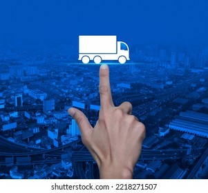 Hand Pressing Truck Flat Icon Over Modern City Tower, Street, Expressway And Skyscraper, Truck Transportation Service Concept