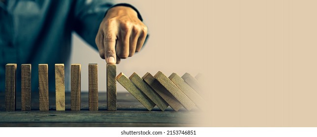 Hand prevent wooden block tower stack crash or fall domino. concept of prevention of financial business and risk management or strategic planning.