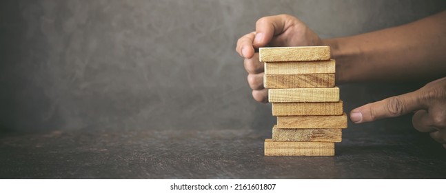 Hand Prevent Wooden Block Tower Stack Not Falling. Concept Of Prevention Of Financial Business And Risk Management Or Strategic Planning.