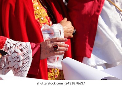 hand of the priest with a ring with a red ruby while giving the blessing to faithful during religious rite