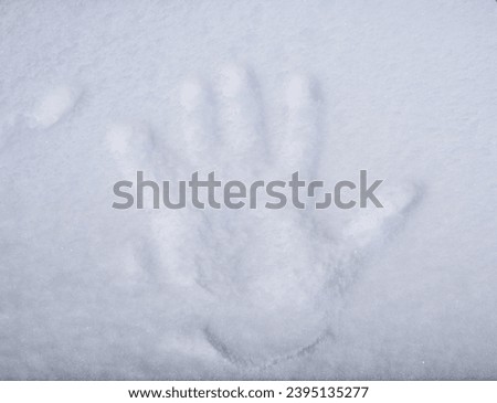 A hand print of big hand in the snow in the snowy Stockholm in the March