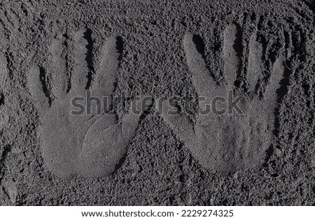 Hand print on Fertile loam soil suitable for planting, texture background. Top view of fresh soil. Concept of global pollution, World Soil Day