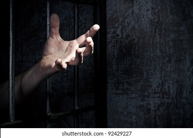 Hand of the prisoner on a steel lattice close up