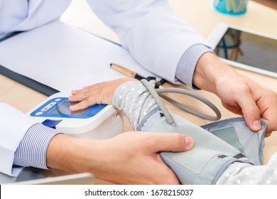 Hand Professional Doctor Check Blood Pressure With Kid Patient.