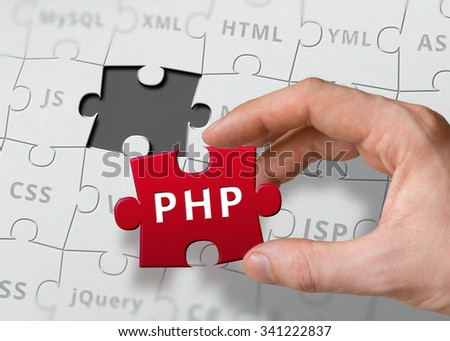 Hand of programmer holds puzzle with PHP programming language written.