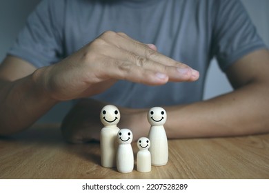 Hand Protect Family Wooden Doll For Insurance Planning Protection And Safety Family Health Insurance Concept.