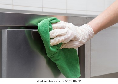 Hand In Protective Glove With Rag Cleaning Kitchen Equipment In The Professional Kitchen. Stainless Steel Surface. Early Spring Cleaning Or Regular Clean Up.