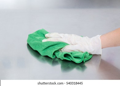 Hand In Protective Glove With Rag Cleaning Kitchen Equipment In The Professional Kitchen. Stainless Steel Surface. Early Spring Cleaning Or Regular Clean Up.
