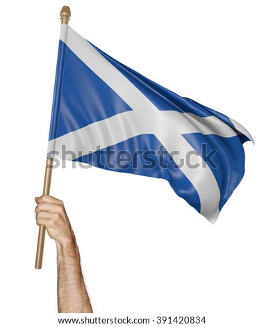 Hand proudly waving the national flag of Scotland