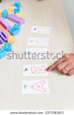 Hand of a psychopedagogue showing letters with letters of the alphabet. Educational help. Mental health care.