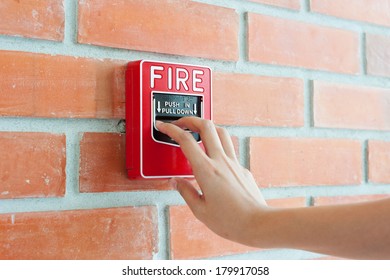 Hand Pulling Down The Fire Alarm Button