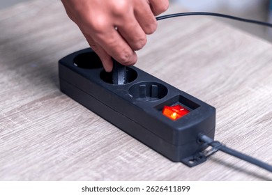 Hand pulling or inserting the plug into the electrical extension cord socket