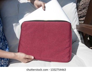 Hand Pulling Laptop Out Of Red Laptop Bag