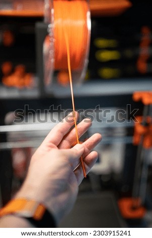 Hand pulling out 3d printing material. 3d printer filament.