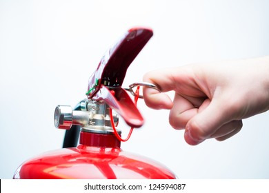 Hand pulling pin of fire extinguisher