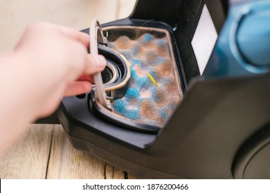 A hand pulls a dirty filter out of the vacuum cleaner. Cleaning of garbage. Vacuum cleaner device. - Shutterstock ID 1876200466