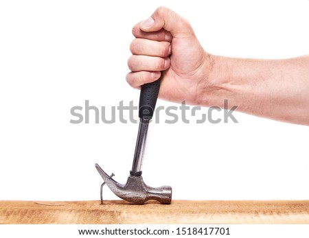 Hand pulls hammer nail out of the Board, on an isolated white background.