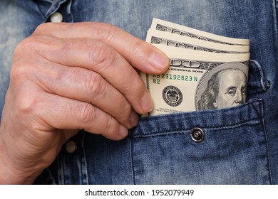 A Hand Pulls Out A Hundred Dollar Bills From A Denim Shirt Pocket. Close Up.