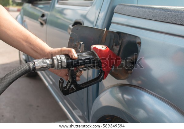 Hand Pumping Gas Into\
Car.