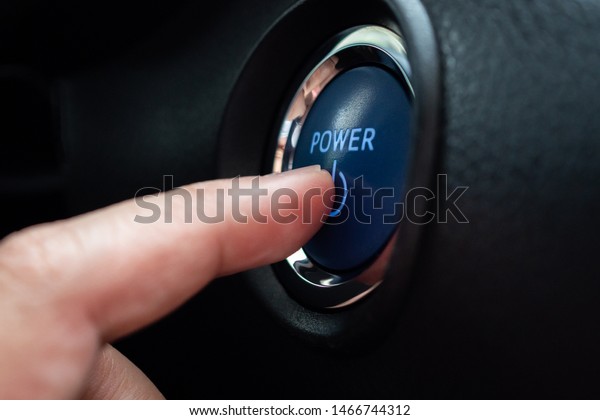 Hand push\
on car engine power start button close\
up
