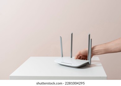 hand push the power on button of the wifi router, internet connection equipment - Shutterstock ID 2281004295